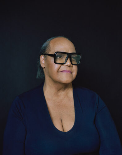Portrait of Miss Major Griffin Gracy with hair tied back and large square black glasses